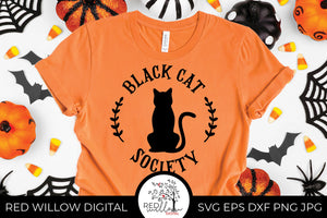 Black Cat Society SVG on an orange t-shirt with halloween decor surrounding it.