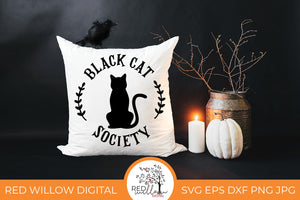 Black Cat Society SVG on a white throw pillow with halloween decor surrounding it.