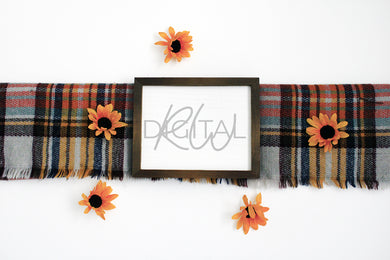 Rustic wood sign displayed horizontally on a fall colored blanket surrounded by sunflowers.