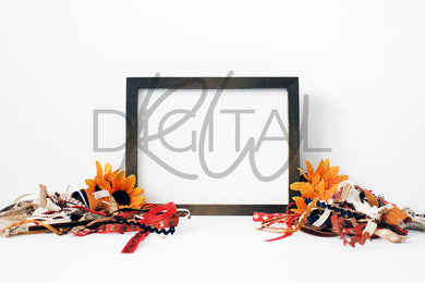 Rustic wood sign displayed horizontally with fall tassels and sunflowers surrounding it. 